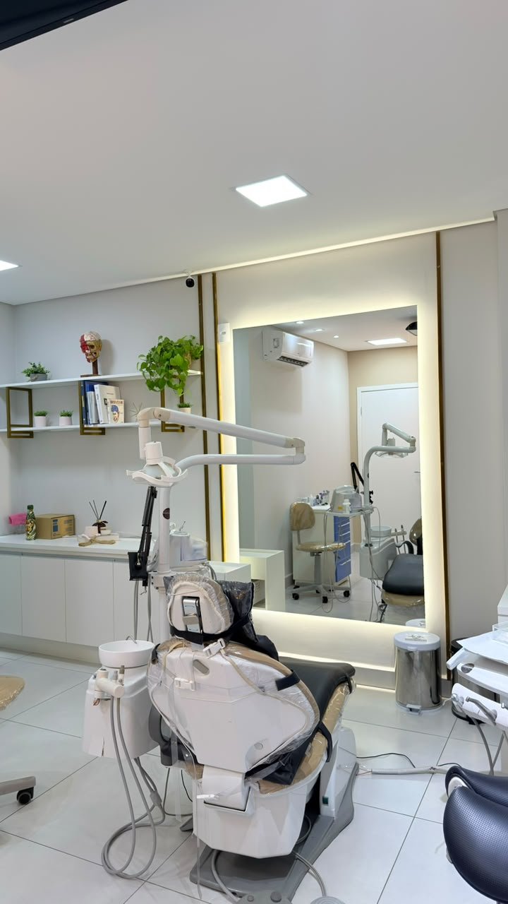 Consultório da Diniz Odontologia com cadeira odontológica e espelho iluminado