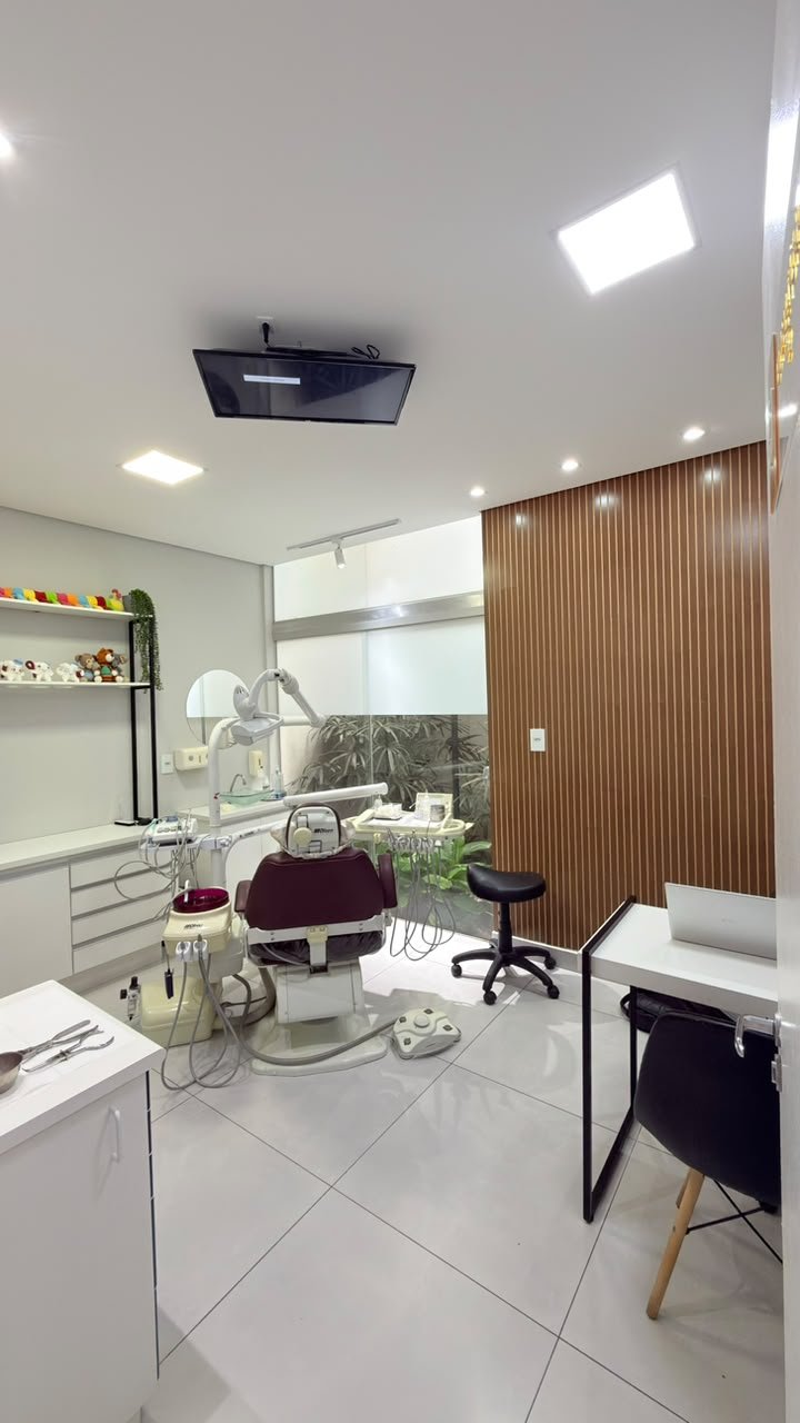 Consultório da Diniz Odontologia com painel de madeira